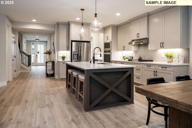 1205 S Mountain Pl, Ridgefield, WA 98642 - kitchen with a sink, appliances with stainless steel finishes, light countertops, under cabinet range hood, and gray cabinetry