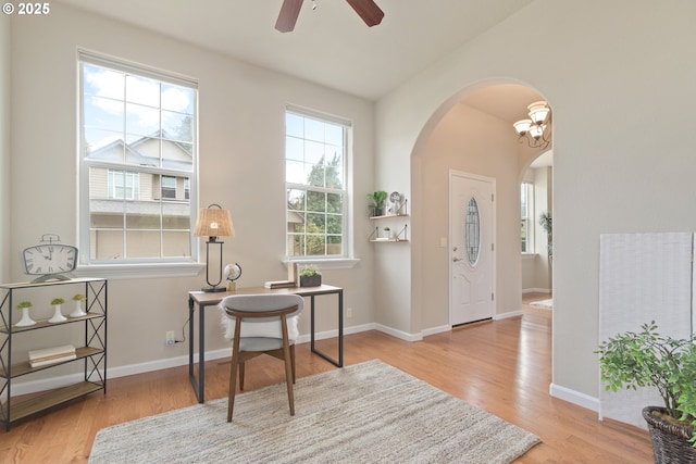 living area featuring light hardwood / wood-style flooring and ceiling fan with notable chandelier