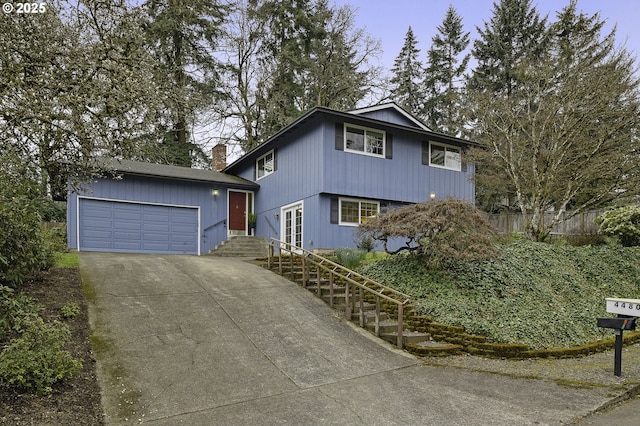 view of front of home featuring driveway, a garage, and fence