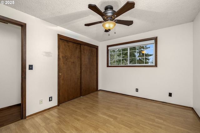 unfurnished bedroom with light wood finished floors, baseboards, a closet, a textured ceiling, and a ceiling fan