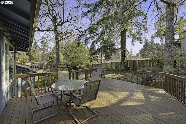 deck featuring outdoor dining space and a fenced backyard