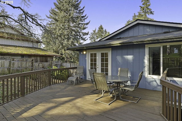 wooden deck with french doors, outdoor dining area, and fence