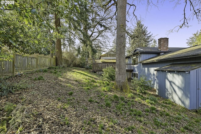 view of yard with a deck and fence