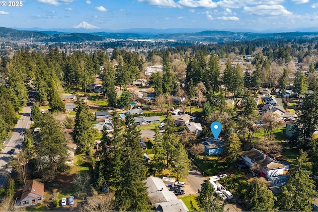 birds eye view of property featuring a mountain view and a wooded view