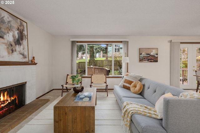 living room featuring a brick fireplace and baseboards