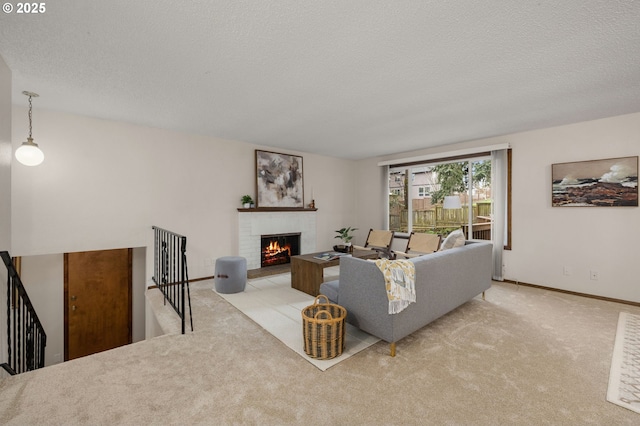 carpeted living room featuring a brick fireplace, baseboards, and a textured ceiling