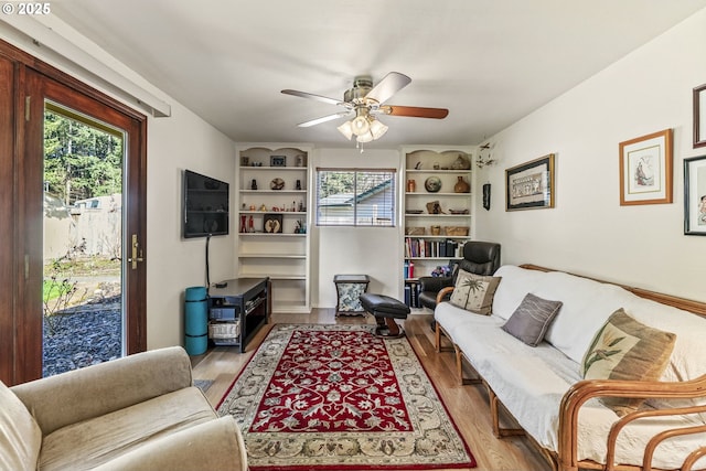 living area with a ceiling fan and wood finished floors