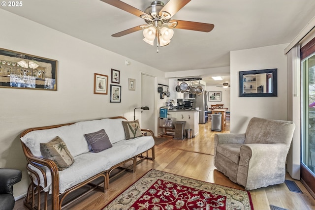 living area with ceiling fan and wood finished floors