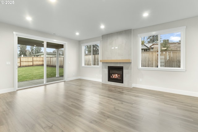 unfurnished living room with visible vents, wood finished floors, recessed lighting, a fireplace, and baseboards