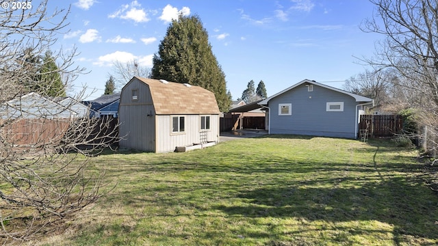 view of yard with an outbuilding, a storage unit, and a fenced backyard