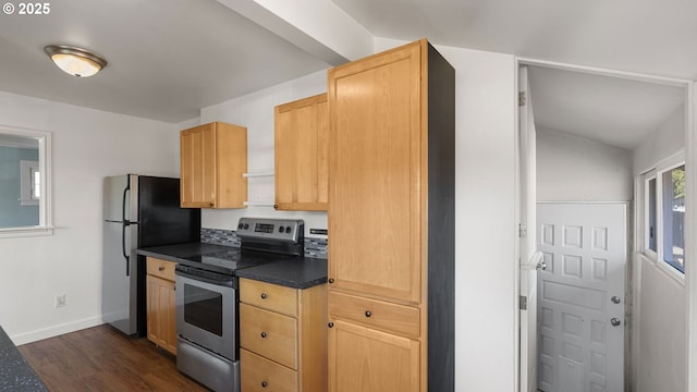 kitchen featuring dark wood-style floors, dark countertops, appliances with stainless steel finishes, light brown cabinets, and baseboards