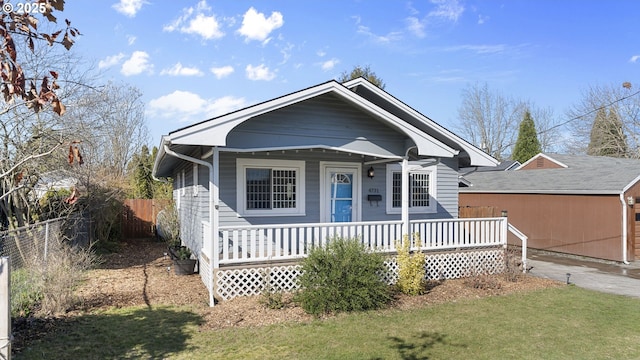 bungalow-style home featuring a porch, a front yard, and fence