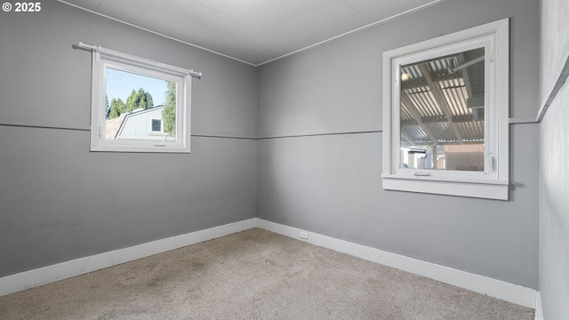 spare room featuring baseboards and carpet flooring