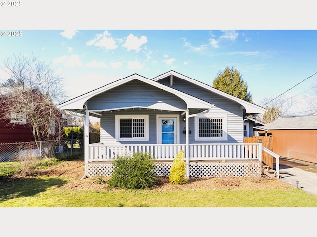 bungalow-style home with covered porch and fence