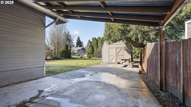 view of patio featuring a storage unit, fence, and an outdoor structure