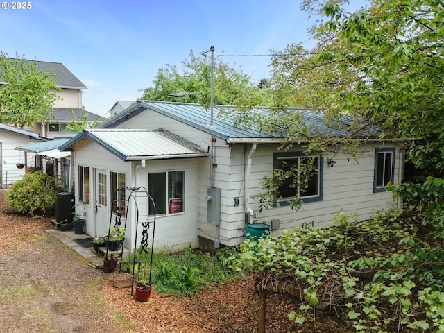 view of front of property with metal roof and cooling unit