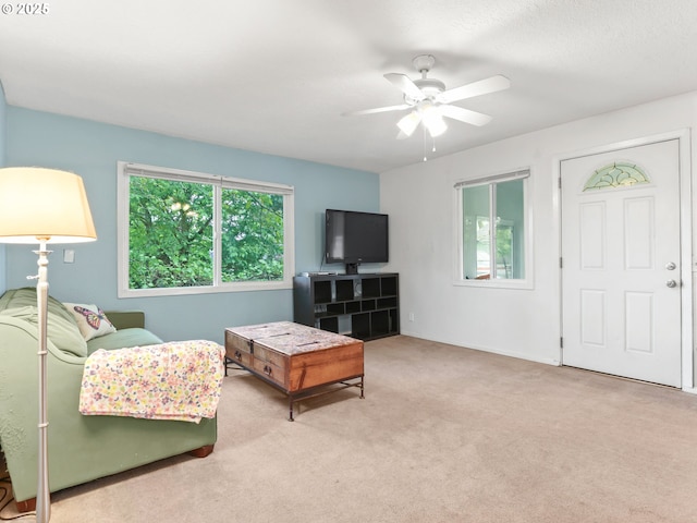 carpeted living room with ceiling fan
