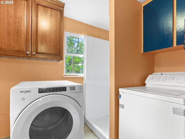 washroom with washer and clothes dryer and cabinet space