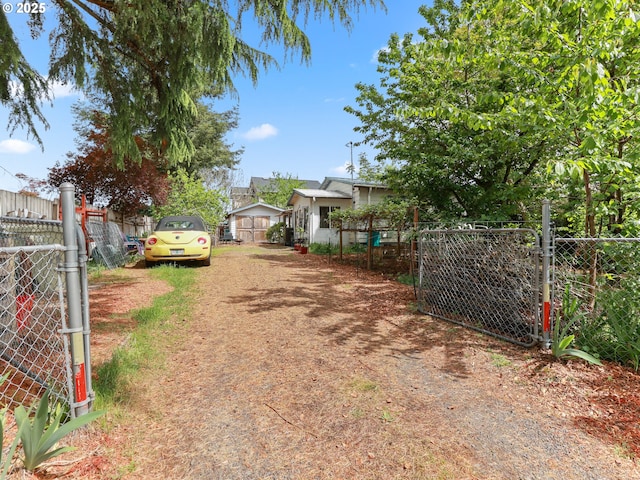 view of street with driveway, a gated entry, and a gate