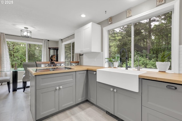 14011 NE 346th St, Battle Ground, WA 98604 - kitchen featuring gray cabinetry, wood counters, light wood-style flooring, a peninsula, and plenty of natural light