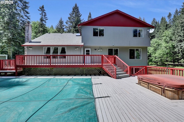14011 NE 346th St, Battle Ground, WA 98604 - rear view of property featuring a covered hot tub, a deck, a covered pool, and a chimney