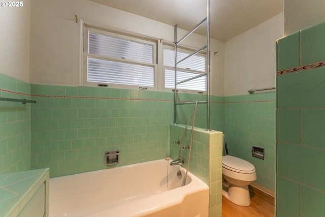 176 N Henry St, Coquille, OR 97423 - bathroom with tile walls, toilet, wainscoting, and wood finished floors