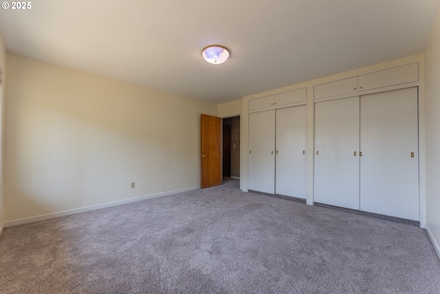 176 N Henry St, Coquille, OR 97423 - unfurnished bedroom featuring two closets, light colored carpet, and baseboards