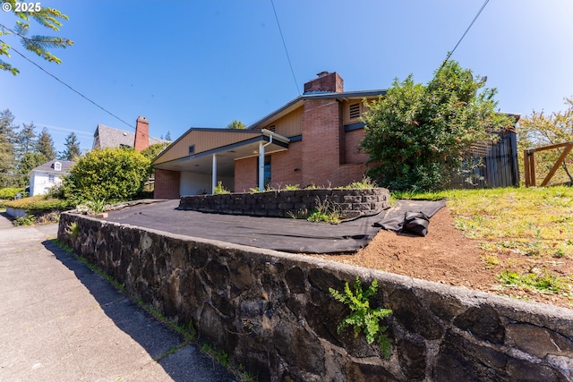 176 N Henry St, Coquille, OR 97423 - view of home's exterior featuring brick siding and a chimney
