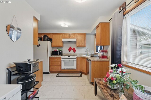 1315 SE 135th Ave, Portland, OR 97233 - kitchen with stainless steel appliances, under cabinet range hood, light marble finish flooring, a sink, and light countertops