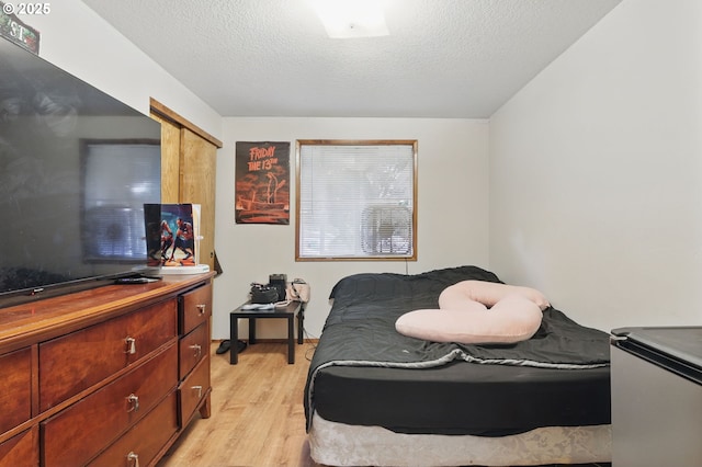 1315 SE 135th Ave, Portland, OR 97233 - bedroom with light wood-style flooring, a desk, and a textured ceiling