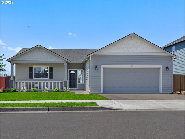 1053 Winfield St NE, Gervais, OR 97026 - ranch-style home with concrete driveway, a garage, covered porch, and roof with shingles