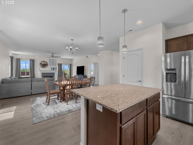 1053 Winfield St NE, Gervais, OR 97026 - kitchen featuring stainless steel fridge with ice dispenser, open floor plan, light wood-style floors, a fireplace, and recessed lighting
