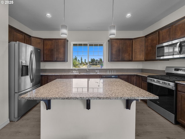1053 Winfield St NE, Gervais, OR 97026 - kitchen with stainless steel appliances, a center island, dark brown cabinets, a breakfast bar area, and recessed lighting