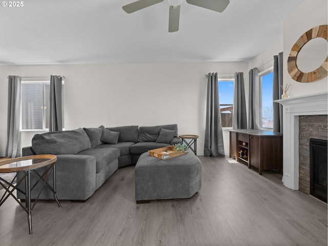 1053 Winfield St NE, Gervais, OR 97026 - living room featuring wood finished floors, a ceiling fan, and a glass covered fireplace