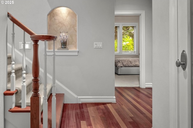 stairs featuring wood finished floors and baseboards