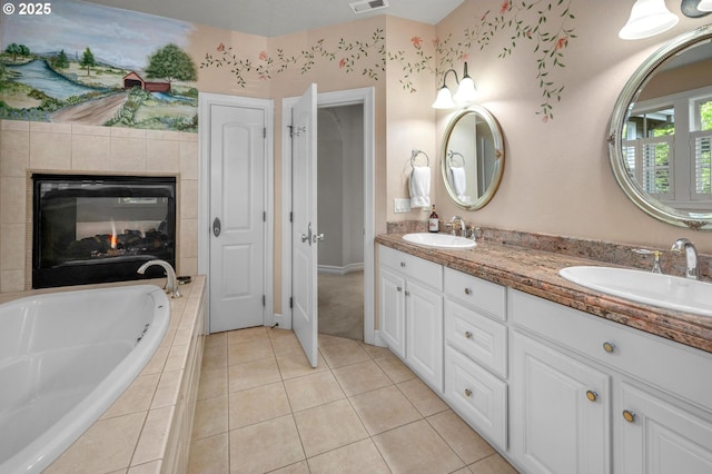 bathroom featuring a tile fireplace, a garden tub, tile patterned floors, and double vanity