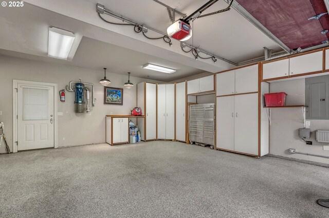 garage with a garage door opener, electric panel, and a central vacuum unit