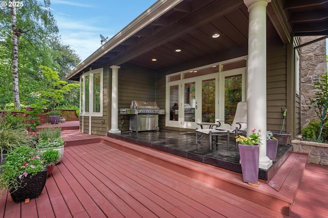 deck with area for grilling, an outdoor kitchen, and french doors