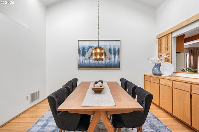 dining area featuring visible vents, a notable chandelier, and light wood-style flooring