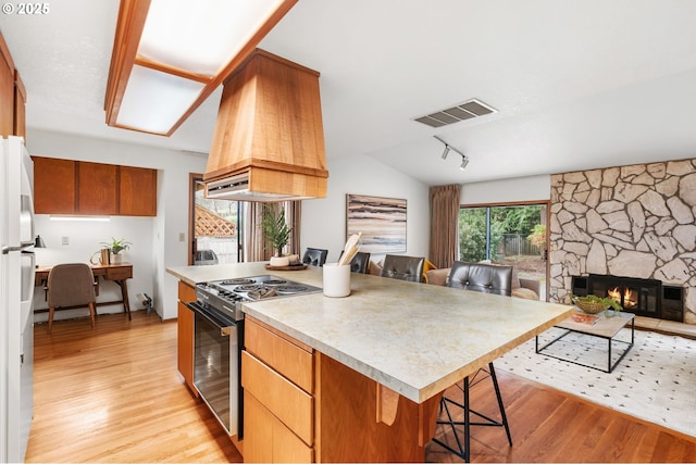 kitchen featuring visible vents, open floor plan, electric range oven, freestanding refrigerator, and custom exhaust hood