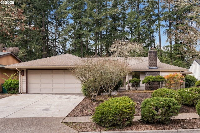 view of front facade with roof with shingles, an attached garage, driveway, and a chimney