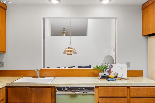 kitchen with dishwasher, light countertops, brown cabinetry, and a sink