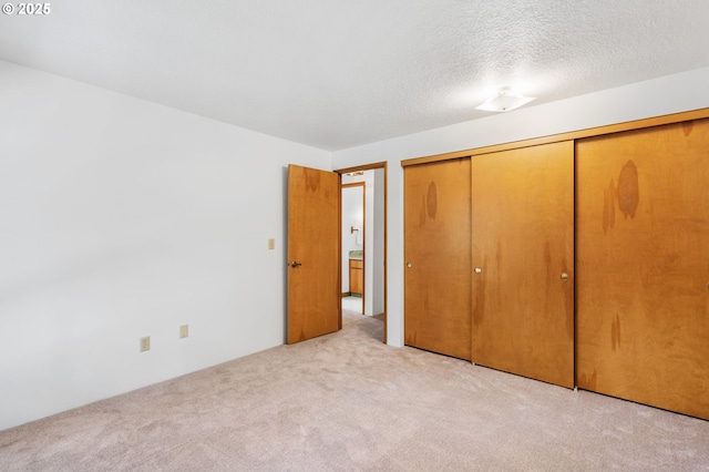 unfurnished bedroom with a closet, carpet floors, and a textured ceiling