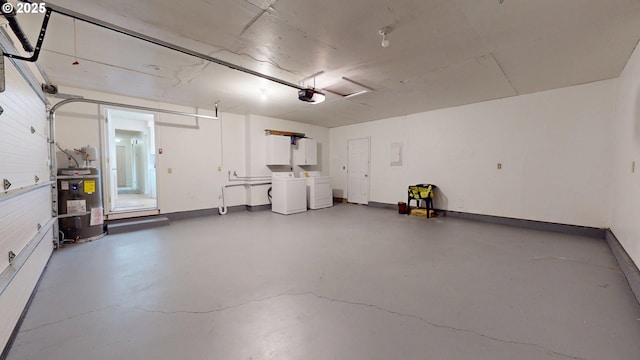 garage featuring baseboards, a garage door opener, washer and clothes dryer, and electric water heater