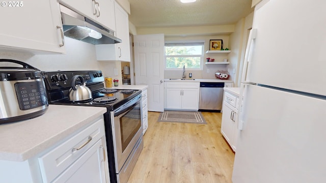 kitchen featuring white cabinetry, under cabinet range hood, a sink, light wood finished floors, and stainless steel appliances