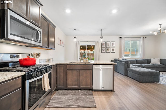 3563 SE Richey Rd, Gresham, OR 97080 - kitchen with appliances with stainless steel finishes, a sink, dark brown cabinets, light wood-type flooring, and a peninsula
