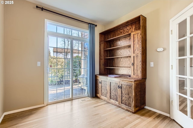 interior space featuring light wood-style flooring, visible vents, and baseboards