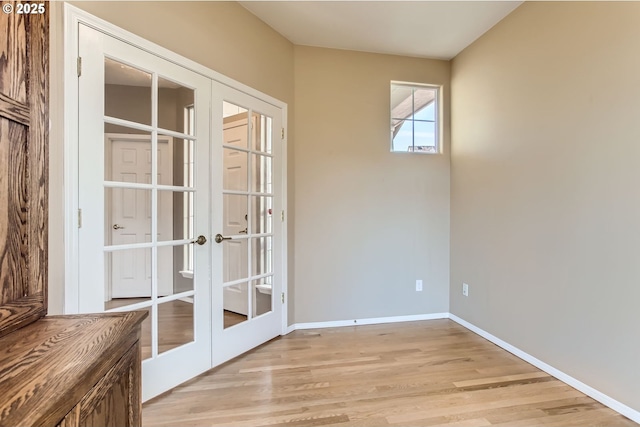 doorway to outside with french doors, light wood-style flooring, and baseboards