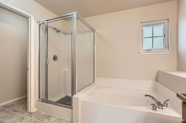 full bath featuring a stall shower, baseboards, and a bath