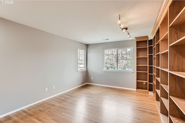 unfurnished room with visible vents, baseboards, and wood finished floors